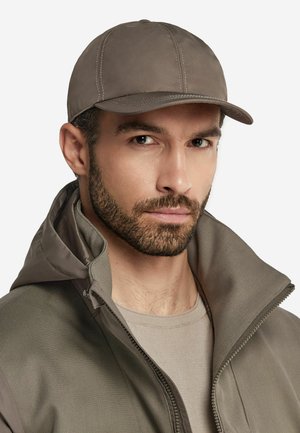 Cappello grigio con visiera curvata, realizzato in un tessuto liscio con cuciture visibili. Indossato con una giacca grigia con zip e colletto alto.