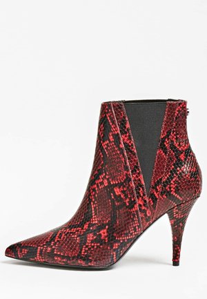 Bottine à bouts pointus avec motif peau de serpent rouge et noir, talon stiletto de hauteur moyenne et panneaux latéraux élastiques noirs.