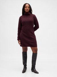 Rochie pulover guler înalt burgundy cu model texturat în formă de diamant; mâneci lungi și siluetă ajustată, asortată cu cizme negre până la genunchi.