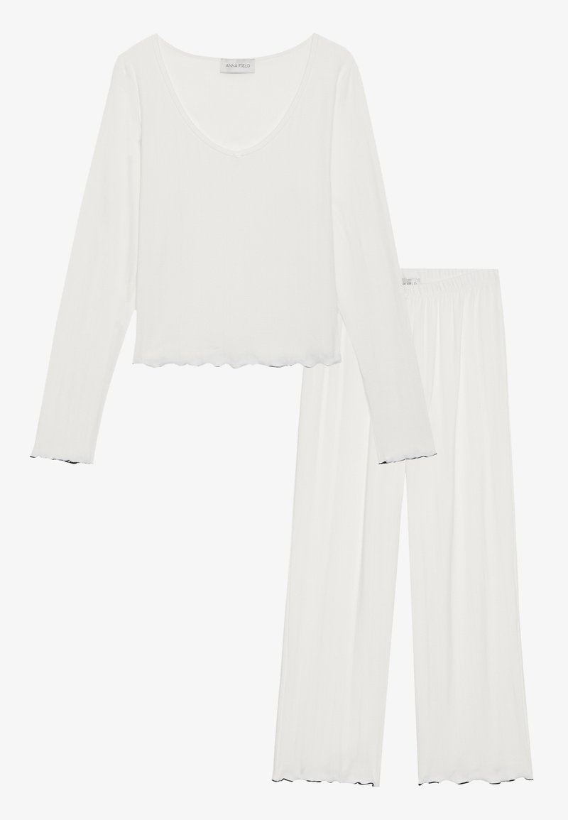 Ensemble de vêtements de détente deux pièces blanc, comprenant un haut à manches longues avec un décolleté en forme de cœur et des bords en dentelle, associé à un pantalon à jambes larges.