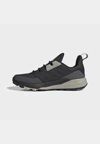 Schwarzer Sportschuh mit einem strukturierten Mesh-Obermaterial, verstärkter Zehenpartie, grauen Akzenten, Schnürverschluss und einer robusten Gummisohle.