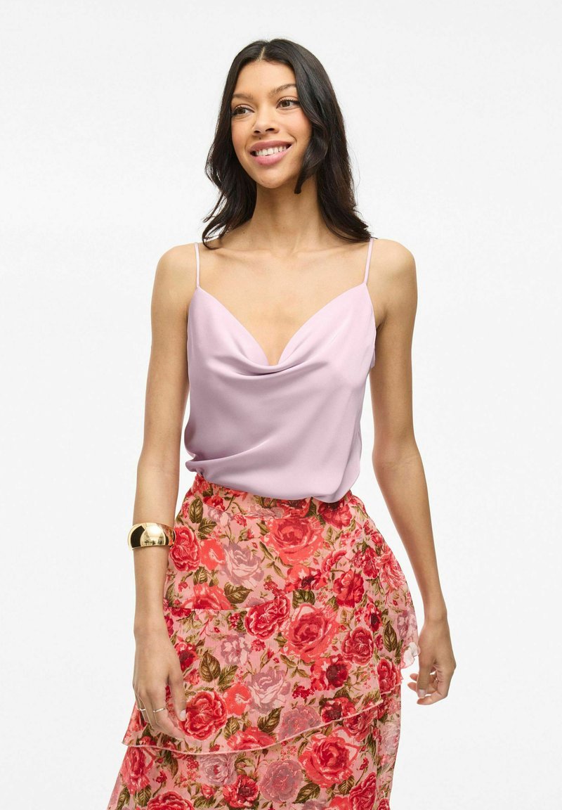 Camisola di raso lavanda con scollo drappeggiato e spalline sottili, abbinata a una gonna a strati rosa con motivi floreali e rose.