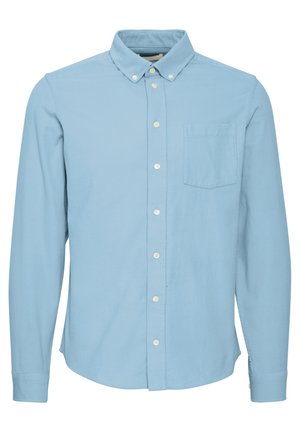 Chemise bleu clair à manches longues en coton, avec un col boutonné, une poche poitrine unique et une fermeture à boutons sur le devant. Texture lisse.