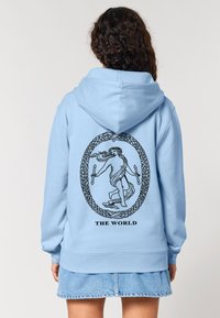 Felpa blu chiaro con un grande grafico nero sul retro che rappresenta una figura circondata da un design ovale di corda e la scritta "IL MONDO."