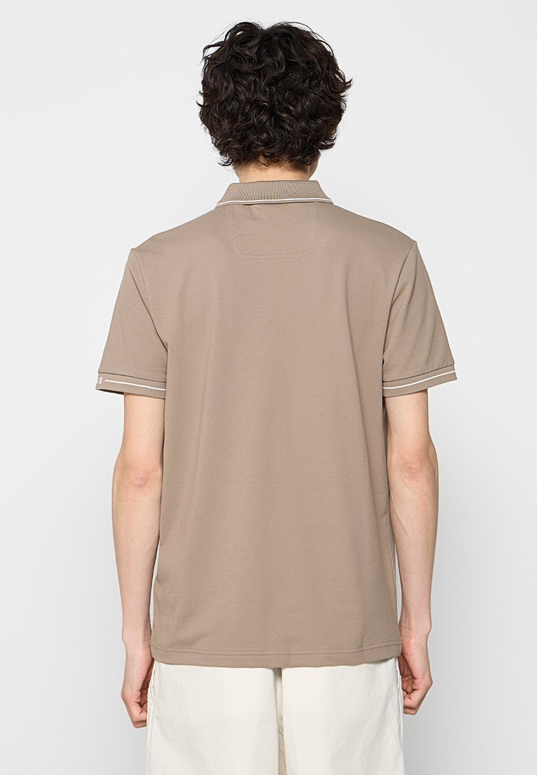 Braunes Polohemd mit kurzen Ärmeln und kontrastierenden weißen Akzenten. Weicher Stoff, klassischer Kragen und gerader Saum. Schlichtes Design ohne Logos oder Muster.