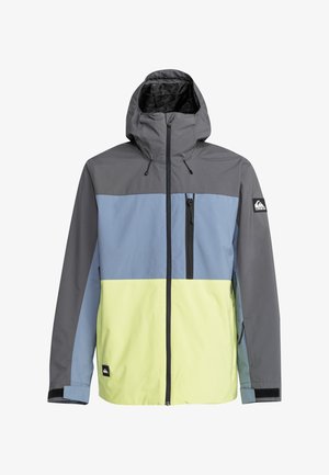 Kleurgeblokte jas in grijs, lichtblauw en geel. Heeft een capuchon, een voorkant rits en zijzak. Gladde, lichte stof.