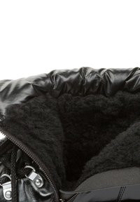 Botas estilo puffer negras con un exterior brillante, presentando un forro suave y peludo en negro y un cierre de cremallera metálica.