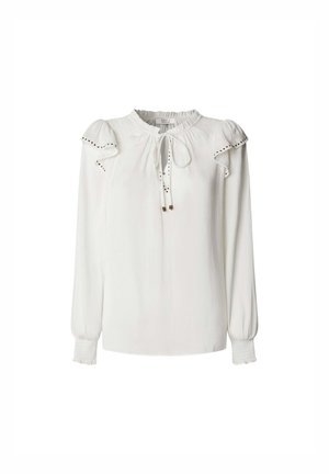 Blouse blanche avec un col rond, un détail de lien, des manches bouffantes et des coutures décoratives le long des épaules et des poignets. Texture de tissu lisse.