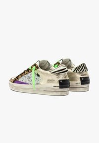 Sneaker bianche a basso profilo con stampa leopardata, pannelli di glitter argento, lacci verde neon, dettagli viola e linguette sul tallone a strisce zebra.