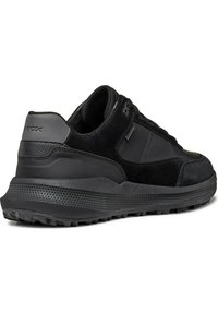 Black sneaker featuring a combination of suede and synthetic materials. Thick rubber sole with textured grip and subtle branding detail.