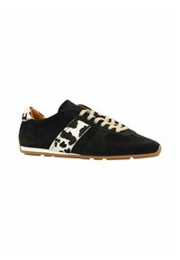 Zwarte suède sneakers met een wit en zwart koeienvlekkenaccent, beige veters en een gestructureerde bruine rubberen zool.