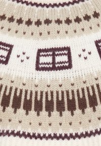 Striktrøje med et mønsterdesign i beige, brun og creme farver, herunder geometriske former og gentagne motiver. Blød tekstur.