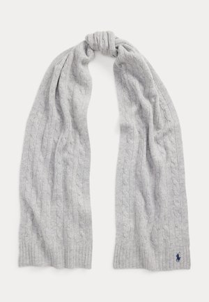 Écharpe en laine tricotée gris clair avec motif torsadé, nouée en haut, avec un petit logo brodé bleu foncé près d'une extrémité.