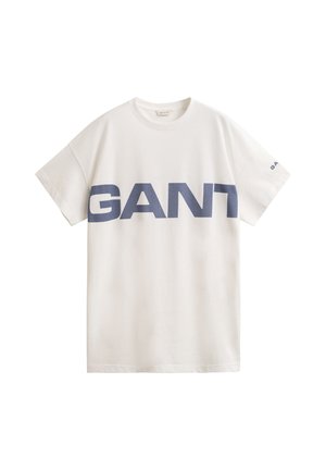 Witte T-shirt met korte mouwen en grote blauwe tekst "GANT" over de borst, met kleinere "GANT" tekst op de linkermouw.