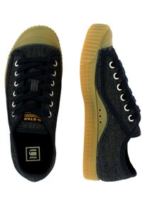 Dark blue denim sneakers feature a rubber sole with a textured finish. White laces and eyelets complement the overall design.