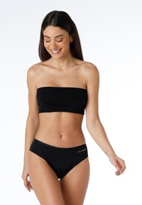 Top bandeau nero e bikini coordinato realizzati in tessuto morbido, con un accentuato logo sulla fascia in vita.