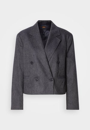 Blazer grigio doppiopetto con tessuto testurizzato, revers a scallo e due tasche frontali. Presenta bottoni neri e un design cropped.