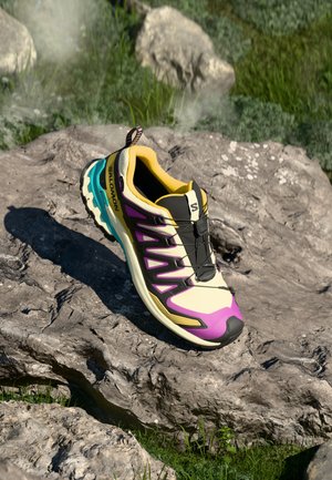 Scarpe da corsa con un design crema, viola e verde acqua. Presentano una tomaia in rete leggera, una suola testurizzata e una punta rinforzata.