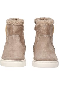 Botines de ante marrón con un suave collar de pelo, que presentan una suela blanca plana y un detalle decorativo lateral. Textura suave en todo el zapato.