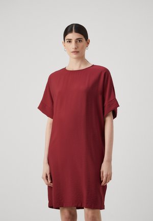 Burgundy klänning i lätt material, med en enkel rund halsringning och korta ärmar med subtil textur samt en avslappnad passform.