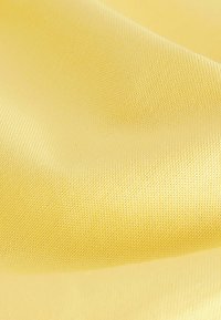 Tessuto giallo con una superficie testurizzata, che mostra una fine trama e una lucentezza liscia, adatto per varie applicazioni tessili.