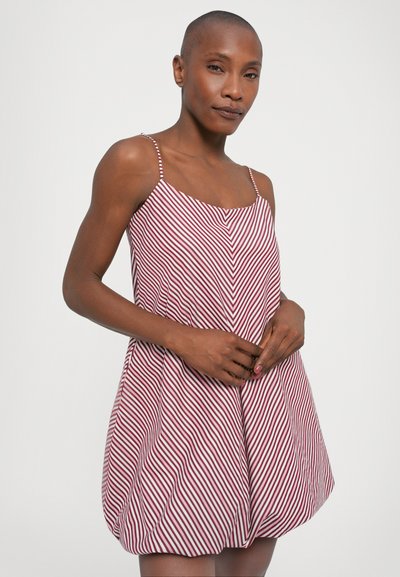 Κόκκινο και άσπρο ριγέ φόρεμα με λεπτές τιράντες, στρογγυλή λαιμόκοψη και ελεύθερη, φαρδιά σιλουέτα που συγκεντρώνεται στο κάτω μέρος.