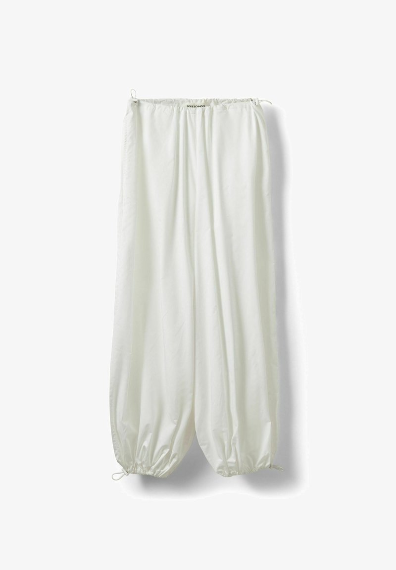 Pantalon blanc ample avec cordons élastiques à la taille et aux chevilles, suspendu sur un fond blanc.