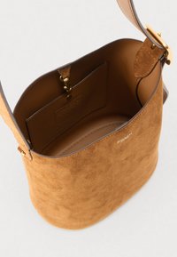 Barna velúr táska sima, lekerekített formával, béléssel, arany színű kiegészítőkkel és belső zsebbel.