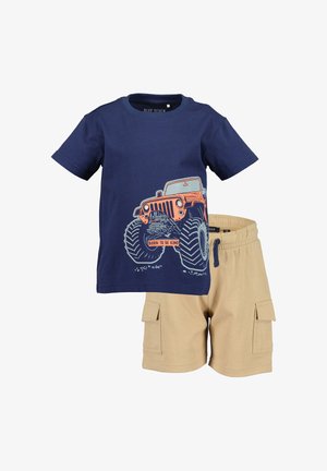 T-shirt bleu marine pour enfants avec un motif de camion monstre orange et un short cargo beige avec poches latérales et taille à cordon.