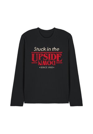 Black long-sleeve shirt with the text "Stuck in the UPSIDE DOWN" in cream and red letters, and "Since 1983" below.