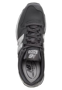 Musta lenkkarit harmailla yksityiskohdilla, joissa on sileä synteettinen päällinen, pyöreä kärki, nauhat ja pehmustettu pohjallinen, jossa on logodetalji.