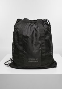 Mochila negra con cordón, hecha de nylon, con lados de malla, que presenta un extremo fruncido, correas ajustables y el logo "URBAN CLASSICS".