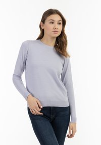 Pulover lung cu maneci lungi, de culoare mov deschis, cu guler rotund și manșete și tiv cu dantelă. Textură moale, design slim-fit, cu detalii minime.
