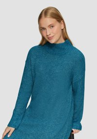 Maglione a collo alto lavorato a maglia color teal con un design testurizzato, polsini a costine e vestibilità comoda, che si estende fino a metà coscia.