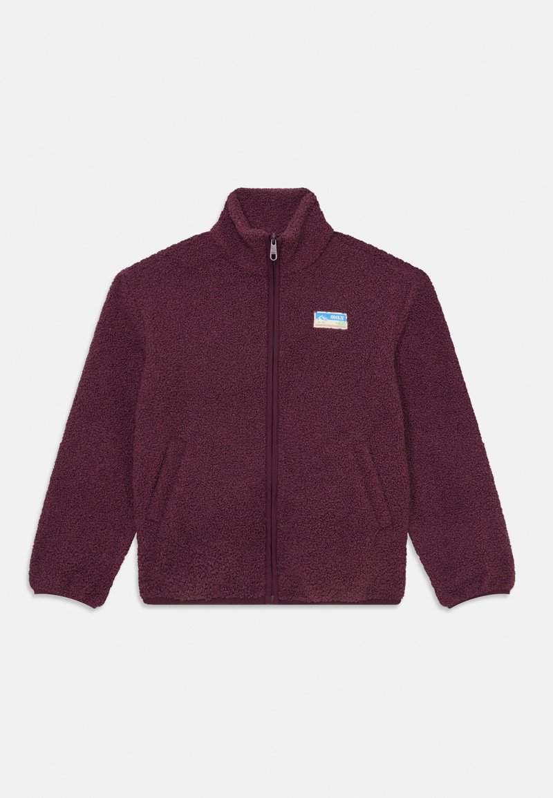 Burgundijas fleece jaka ar augstu apkakli, priekšējo rāvējslēdzēju un divām sānu kabatām; uz kreisās krūtis ir palaists logo uzlīmīte.