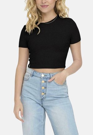 Camiseta negra corta con cuello redondo combinada con jeans de mezclilla azul claro de cintura alta que cuentan con un cierre de cinco botones.