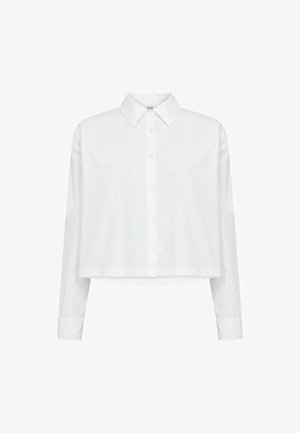 Valkoinen pitkähihaisen pituinen lyhyt napillinen paita, jossa on terävä kaulus ja suora helma.