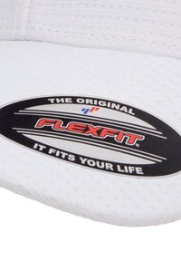 Bijela kapa s teksturiranom tkaninom i crnim ovalnim logotipom na kojem piše "FLEXFIT" crvenom bojom, uz slogan "ODGOVARA Tvojim ŽIVOTU."