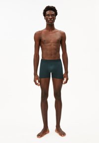 Donkergroene boxershorts met een strakke pasvorm, voorzien van een zwarte tailleband met het "ARMEDANGELS" logo, gemaakt van zacht, rekbaar materiaal.