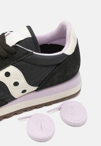 Sorte semsket og tekstil sneakers med hvite detaljer, lavendelfarget såle og lys lilla snørebånd. Har teksturert overflate og avrundet design.