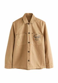 Hnědá pracovní bunda vyrobená z bavlny. Obsahuje zapínání na knoflíky, dvě náprsní kapsy a tištěné logo s textem na levé kapse.