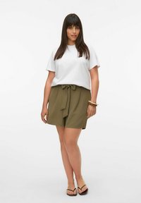 Vit bomull t-shirt, olivgröna högmidjade shorts med knytdetalj, bärs med svarta flip-flops. Slät textur, avslappnad passform.