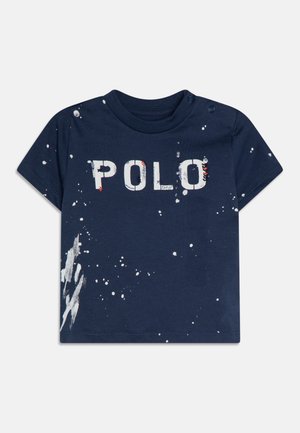 Marineblauw katoenen T-shirt met korte mouwen, met een "POLO"-opdruk in het wit en verfspetteraccenten aan de voorkant en linkerkant.