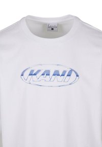 White cotton t-shirt with a round neckline and a blue oval logo featuring the text "KANI" in bold. Smooth texture with short sleeves.