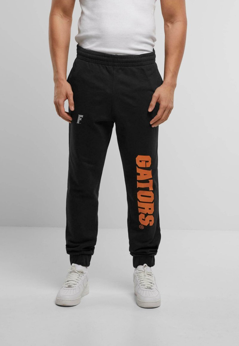 Black sweatpants with an elastic waistband, featuring an orange "GATORS" graphic on the left leg and a small gray logo on the right.