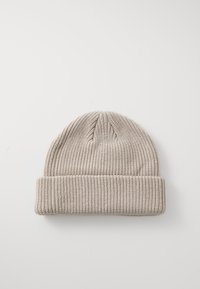 Gehaakte beanie in licht beige met een geribbelde textuur, voorzien van een omgeslagen rand en een afgeronde kroonontwerp.