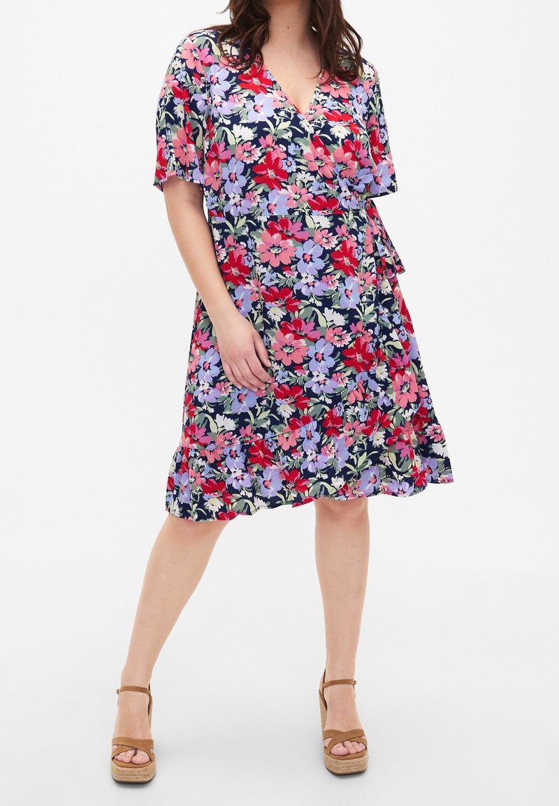 Květinové šaty s krátkým rukávem, hlubokým výstřihem do V a tmavě modrým pozadím. Ozdobené červenými a fialovými květinami, texturovaný lem.