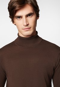 Brązowy sweter z golfem o prążkowanej teksturze, z dopasowanym dekoltem i delikatną fakturą, prezentujący jednolity kolor i prosty krój.