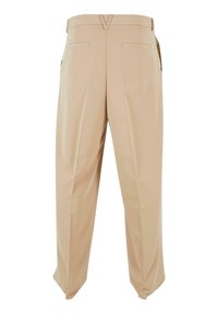 Beige op maat gemaakte broek van een gladde stof, met twee achterzakken en een subtiele V-vormige uitsnijding bij de tailleband. Rechte pijpen met minimale kreukels.