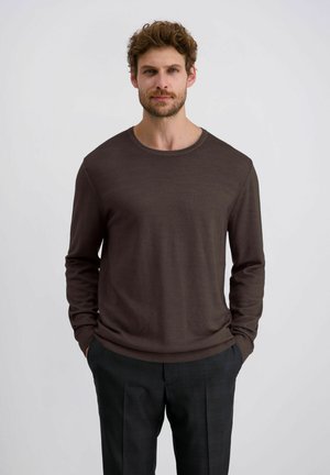 Bruine langemouwen trui met ronde hals, gemaakt van een zacht materiaal, met een gladde textuur en geribbelde manchet, gecombineerd met grijze geruite broek.